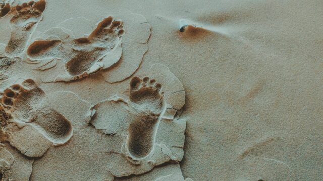 person foot prints on sands photo